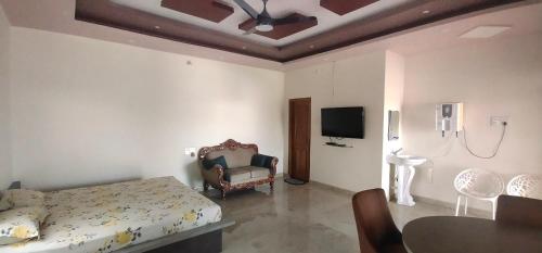 - une chambre avec un lit, une table et une télévision dans l'établissement SHAN Stay No 1, à Mysore