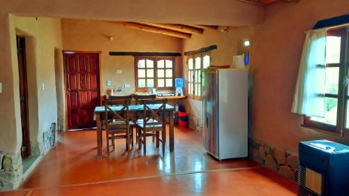 a kitchen with a table and chairs and a refrigerator at MAMAICUNA CABAÑA in Tilcara