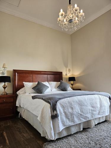 a bedroom with a large bed with a chandelier at Hotel Boutique Terra Diaguita & Spa in La Serena