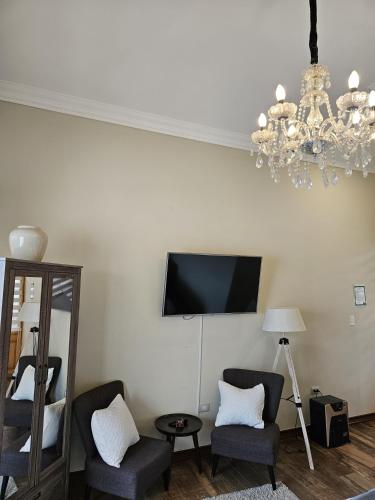 a living room with two chairs and a tv on the wall at Hotel Boutique Terra Diaguita & Spa in La Serena