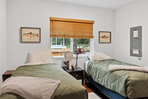 two beds in a room with a window at Mt. Rainier Cabin w/hot tub in Ashford
