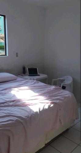 a bedroom with a bed with a laptop on a desk at Apartamento Mossoró in Mossoró