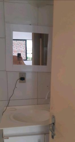 a white bathroom with a mirror and a sink at Apartamento Mossoró in Mossoró