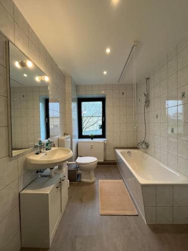 ein Badezimmer mit einem Waschbecken, einer Badewanne und einem WC in der Unterkunft Mikro Apartment Großenhain in Großenhain
