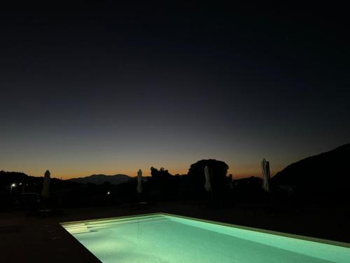 a swimming pool with the sunset in the background at Topos luxury stay Heraion in Loutraki