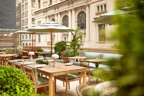 un patio con mesas y sombrillas en un edificio en Grayson Hotel, en Nueva York