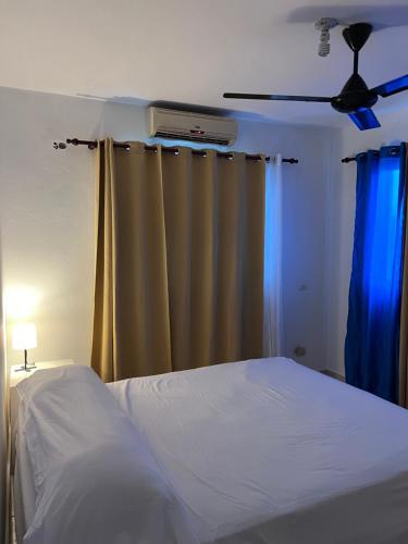 een slaapkamer met een bed en een plafondventilator bij Playa Azul House in Bayahibe