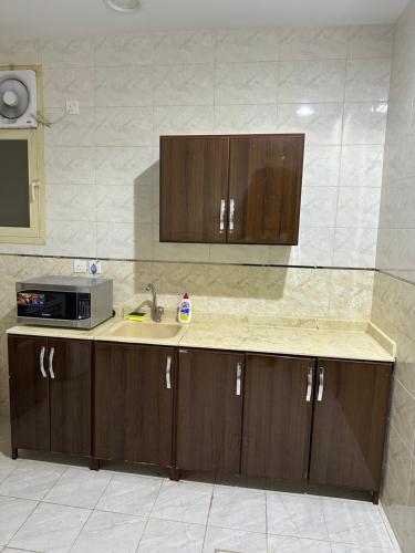 een keuken met een wastafel en een magnetron bij شقة مفروشة غرفتين بدخول ذاتي in Al Kharj