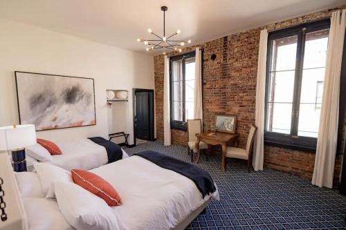 een slaapkamer met 2 bedden en een bakstenen muur bij Speakeasy 2 Room Suite (Rm 4) in Nevada City