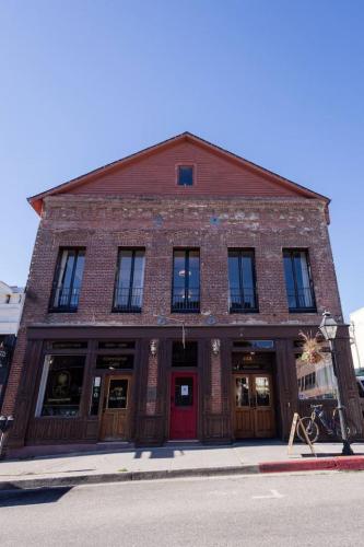 a brick building with a red door on a street at Speakeasy Suites Sleeps 18 in Nevada City