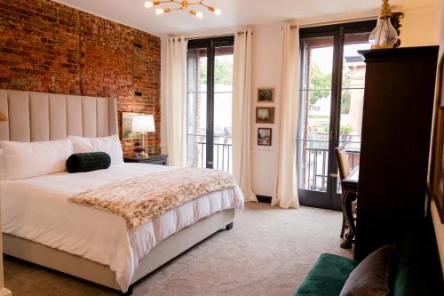 a bedroom with a bed and a brick wall at Speakeasy Suites Sleeps 18 in Nevada City