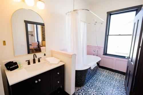 uma casa de banho com uma banheira, um lavatório e um espelho. em Speakeasy King Suite (Rm 8) em Nevada City