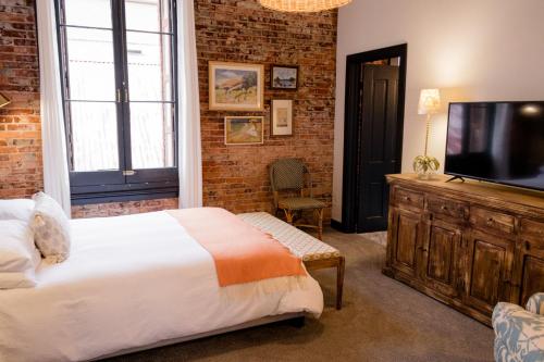 a bedroom with a bed and a flat screen tv at Speakeasy Suites Sleeps 18 in Nevada City