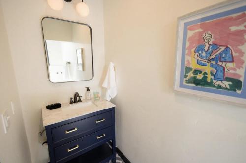 a bathroom with a sink and a mirror and a painting at Speakeasy Queen Suite (Rm 7) in Nevada City