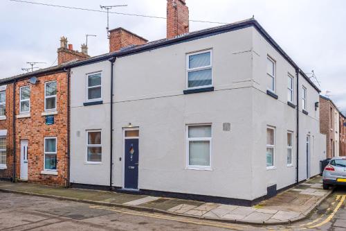 a white house with a blue door on a street at NEW! Stunning City-Centre Home by 53 Degrees Property, ideal for Couples, Amazing Location! in Chester