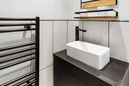 a bathroom with a white sink on a counter at The Buccleuch Luxury Apartments in Kettering