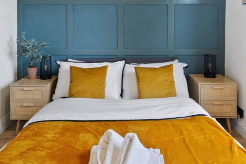 a bedroom with a large bed with yellow sheets and pillows at The Buccleuch Luxury Apartments in Kettering