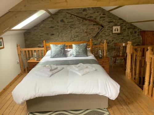 a bedroom with a large bed in a stone wall at Tanyresgair Cottages in Aberystwyth