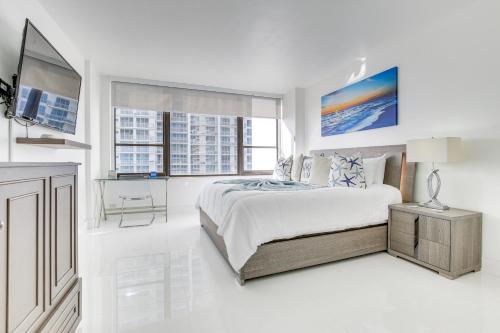 a white bedroom with a bed and a tv at Hollywood Vacation Rental with Direct Beach Access! in Hollywood
