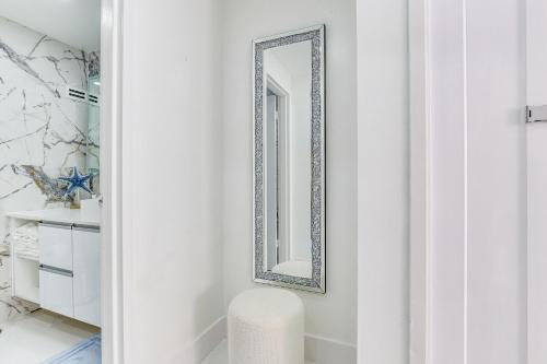 a mirror on a wall in a bathroom with a stool at Hollywood Vacation Rental with Direct Beach Access! in Hollywood