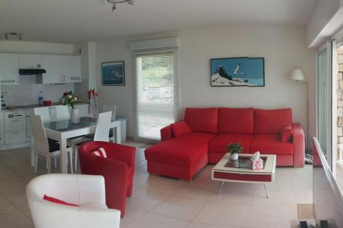 un salon avec un canapé rouge et une table dans l'établissement Résidence Les Roches Blanches, à Trébeurden