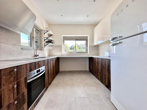 a large kitchen with wooden cabinets and a window at Topos luxury stay Heraion in Loutraki