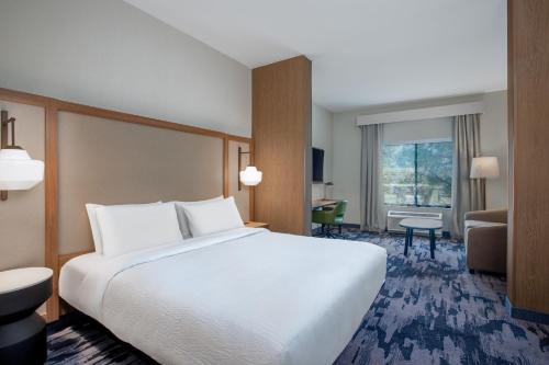 a bedroom with a large bed and a living room at Fairfield by Marriott Inn & Suites Indianapolis Plainfield in Plainfield