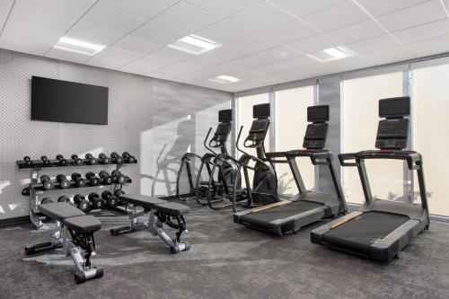 a gym with a row of exercise bikes and a flat screen tv at Fairfield by Marriott Inn & Suites Indianapolis Plainfield in Plainfield