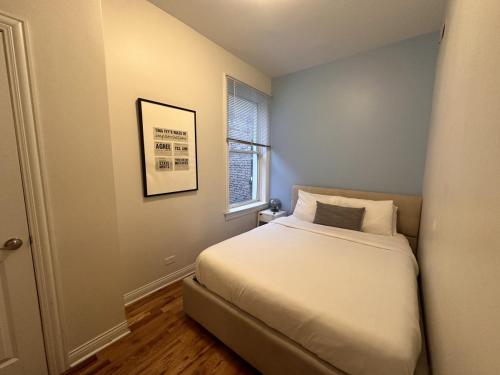 um pequeno quarto com uma cama e uma janela em Flexhome Wicker Park 3BR DV2 - READ INFO em Chicago