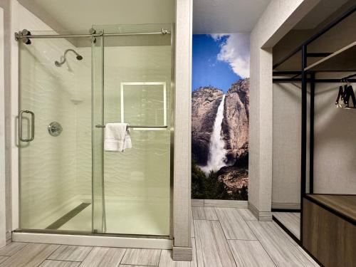 a bathroom with a shower with a waterfall mural at Modesto Hotel - Suite A in Modesto