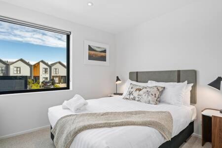 a bedroom with a bed and a large window at Alps Serenity Retreat - Wanaka in Wanaka