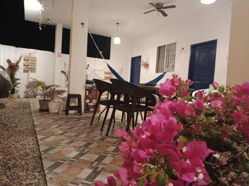 une chambre avec un piano et quelques fleurs roses dans l'établissement Sol de Ayangue, à Ayangue