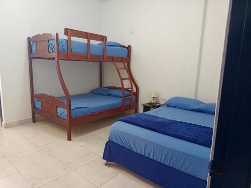 una camera con 2 letti a castello con lenzuola blu di Sol de Ayangue a Ayangue