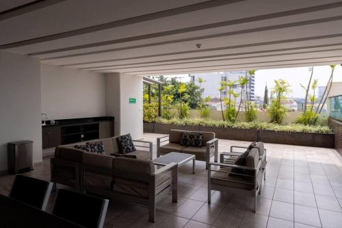 una sala de estar con sofás, mesas y una gran ventana. en Luxury 3BR Penthouse in Astria 1407 en Tegucigalpa