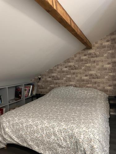 un lit dans une chambre avec un mur de briques dans l'établissement Maison de ville, à Vitry-sur-Seine