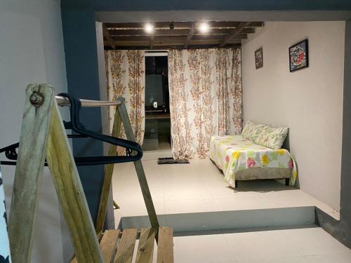 a room with a bed and a staircase with a window at Suite Encantada in Garopaba