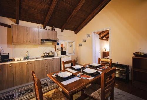 a kitchen and dining room with a wooden table at Sunset Suite - Salamina Island in Salamís