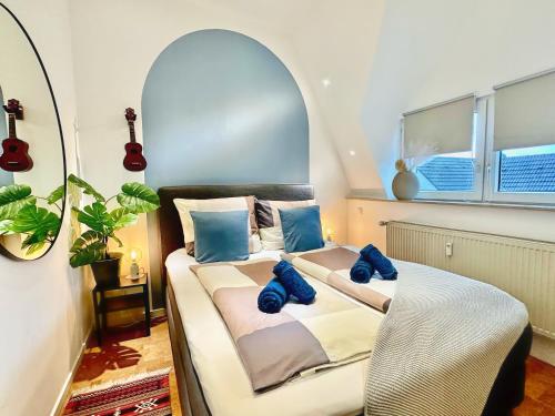 1 dormitorio con 1 cama con almohadas azules en Gemütliche Stadtwohnung nahe des Harkortsees, en Wetter