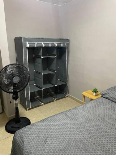 a bedroom with a bed and a black book shelf at Departamento Relax en Tampico in Tampico