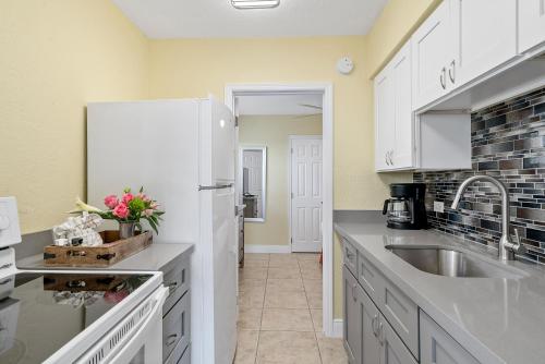 a kitchen with a sink and a white refrigerator at Bay Harbor Lodge in Key Largo