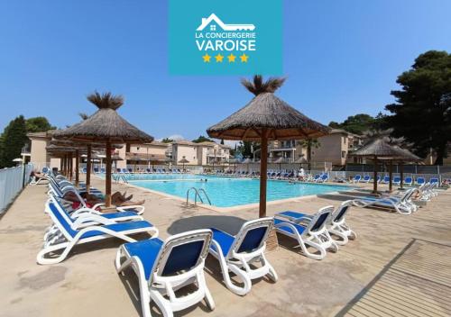 un groupe de chaises et de parasols à côté d'une piscine dans l'établissement L'argentière, proche plage,Résidence piscine, Tennis, parking, à La Londe-les-Maures