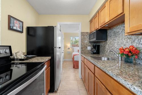 a kitchen with a black refrigerator and a sink at Bay Harbor Lodge in Key Largo