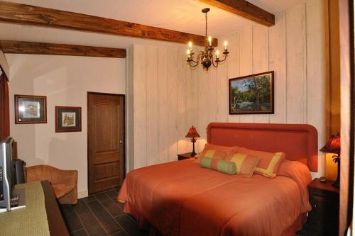 a bedroom with a orange bed in a room at Cabin at Los Titos Coffee Farm 