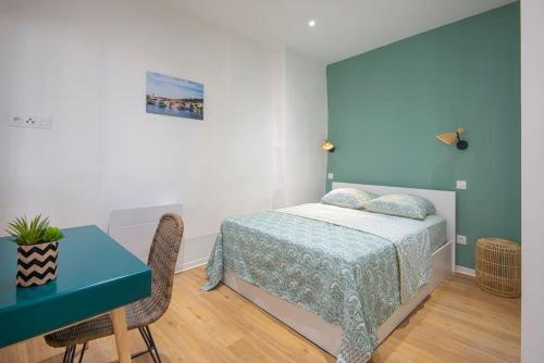 a bedroom with a bed and a table and a desk at Les Halles & Le port - Grand T2 haut de gamme in Toulon