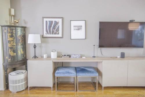 a desk with a tv and two stools in a room at Hollywood Hills: laundry+parking+patio+kitchen+AC in Los Angeles