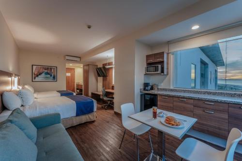 a hotel room with a bed and a living room at La Venta Inn Ciudad del Carmen in Ciudad del Carmen