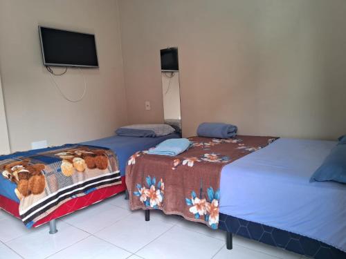 two beds sitting next to each other in a room at Edward Suíte Manaus 03 in Manaus