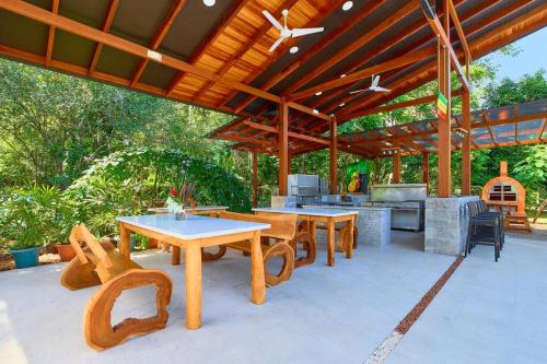 an outdoor patio with tables and a grill and a table and chairs at Casa Kristel - Exquisite Villa Getaway in Puerto Viejo