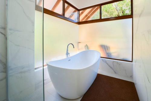 a bathroom with a white tub and a window at Casa Kristel - Exquisite Villa Getaway in Puerto Viejo