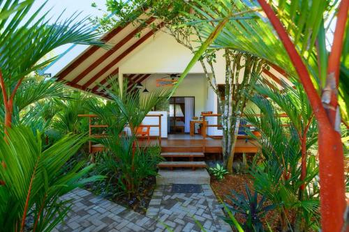 a patio of a house with some palm trees at Casa Kristel - Exquisite Villa Getaway in Puerto Viejo